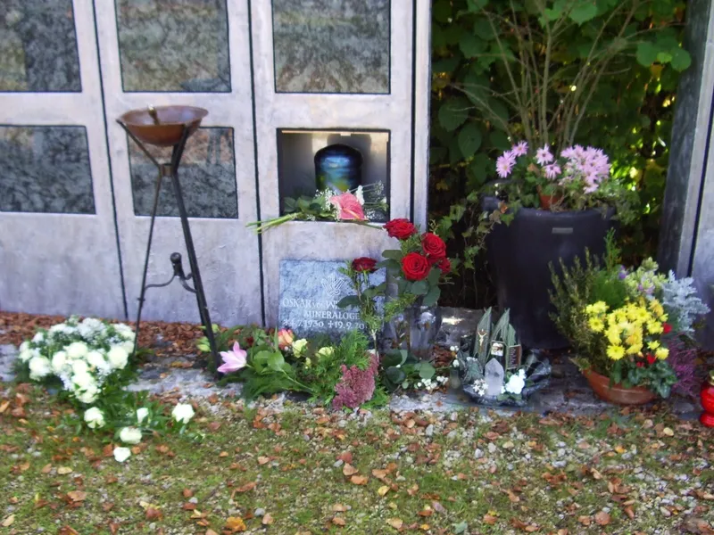 Feuerbestattung – Urnengrab mit Blumenschmuck an einer Urnenwand