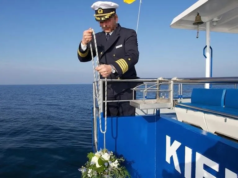 Seebestattung – Kapitän lässt Urne mit Blumenschmuck ins Meer hinab